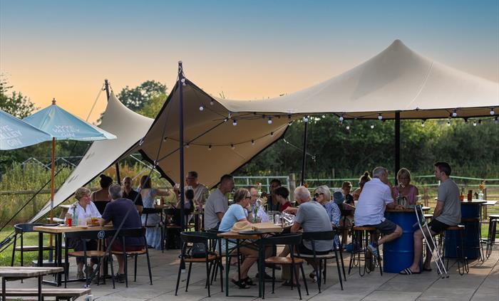 People enjoying cocktails on a patio outside Silver Circle Distillery.
